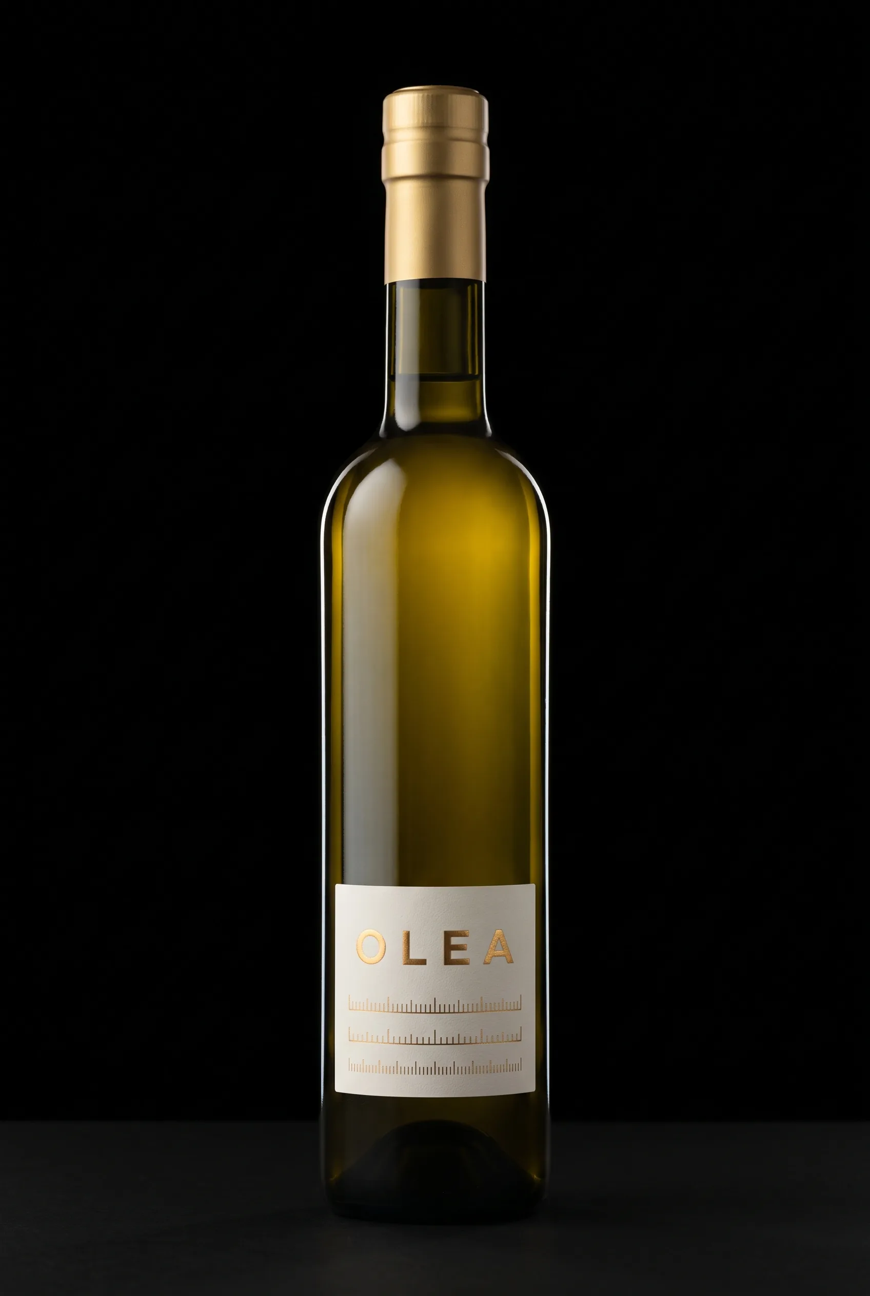 La botella OLEA atravesada por la luz: la columna de aceite se enciende en oro